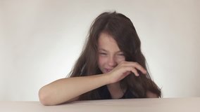 Beautiful sad teenage girl rolls a fit and freaks out on a white background stock footage video