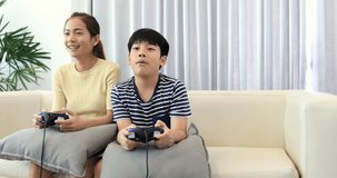 Happy asian family play game with smile face at home. Thai sister and brother playing game together .