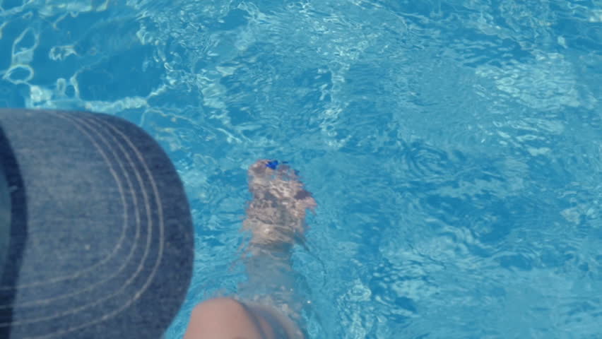 Female feet in the pool water