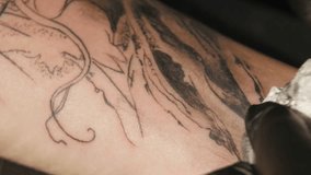 Tattoo artist make tattoo in studio, tattooing on the body. close up.