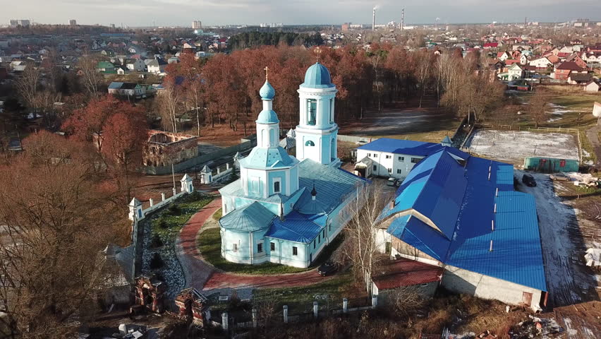 Beautiful orthodox church on the bank of the river Klyazma in the city of Noginsk. Picturesque surroundings with a dam on the river. Sunny autumn day.