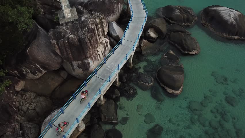 Two cyclists by the ocean drone video