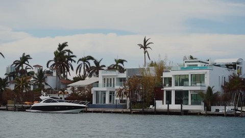 wonderful walking boat near luxurious mansion of wealthy people unde cloudy sky,sunny isles beach,miami