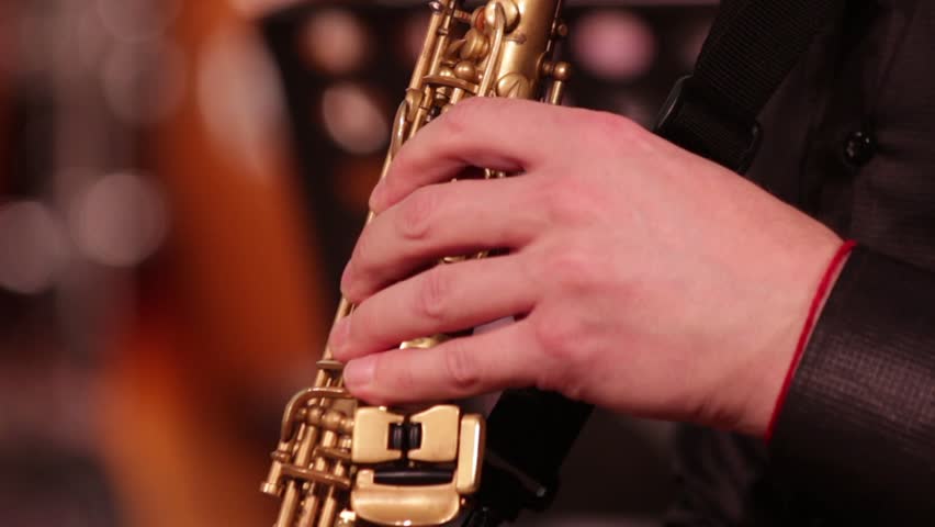 Playing on a wooden wind instrument soprano saxophone. Close-up. The musician retrieves the sounds of music by clamping the keys and ends the game. Royalty-Free Stock Footage #32729908