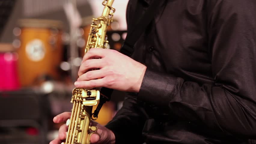 A man with a beard in a black shirt emotionally plays the soprano saxophone. Close-up. Royalty-Free Stock Footage #32738062
