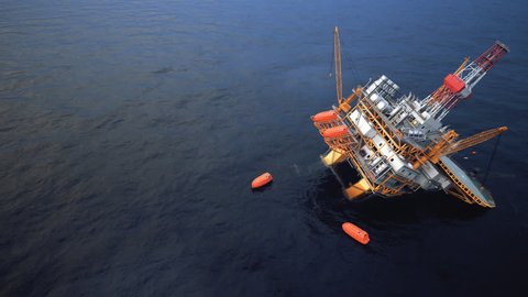 Oil Rig accident. Collapsed Oil Platform. Lifeboats waiting for rescue.
