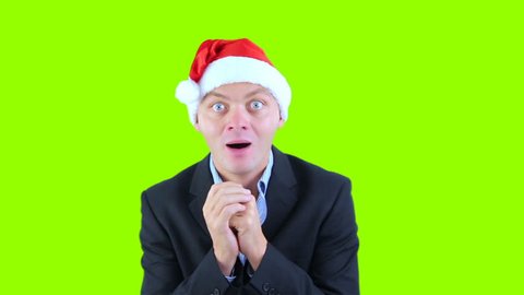Young crazy man in santa hat surprised on chroma key