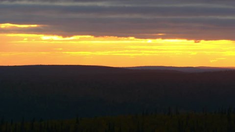 Arctic sunset, Zoom out time lapse of a orange evening dusk, on the top of kaunispaa tunturi fjeld fell, in urho kekkonen national park, lapland, in Lappi, Finland