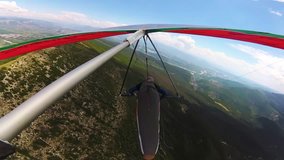  Hang glider pilot flies on high speed over mountain ridge, aerial onboard footage of extreme sport taken with action camera in 4K