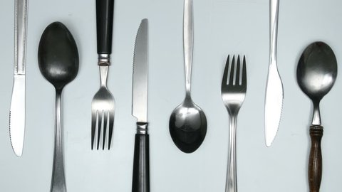 Moving cutlery on white and red background. Cooking jingle concept. Stop motion animation.
