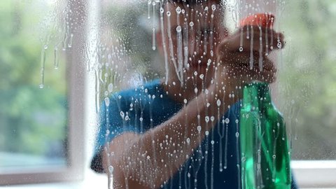 A man washes windows at home