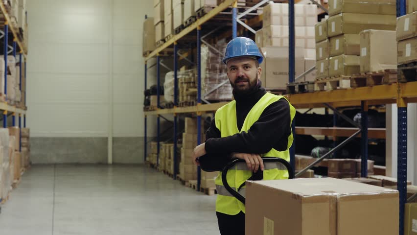 Male warehouse worker standing by pallet truck. | Shutterstock HD Video #32784940