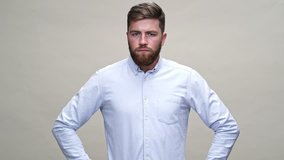 Confused bearded man in shirt do not agree with something over gray background