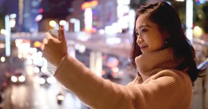 pretty  young asian woman Video chatting on the smart phone at night city background
