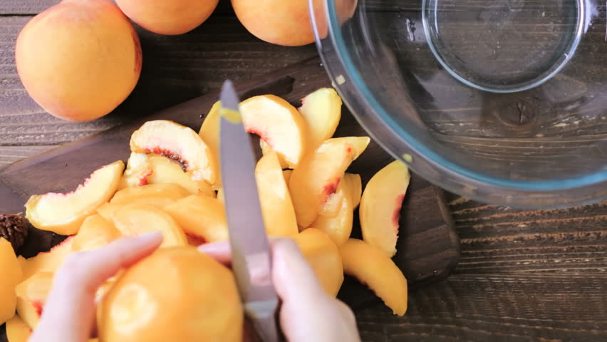 Step by step. Slicing organic peaches for peach cobbler.