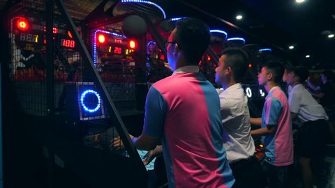 Asian People Playing Basketball and Throwing Ball at Arcade Machine in Game Zone MBK Shopping Center. 4K. Bangkok, Thailand - 15 NOV 2017.