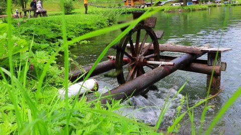 Wooden water wheel turning under power, water mill on a Lake.