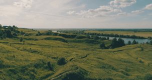 Drone video. Journey through the Golden Ring. Drone flying under juicy grass green meadows and a river bend. Spring summer nature in Russia.