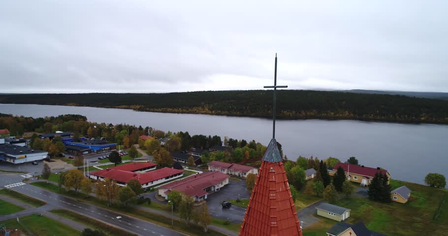 Religious cross, Cinema 4k aerial orbit view around the cross on a church, in hetta town, on a cloudy and foggy autumn day, in Lappi, Finland