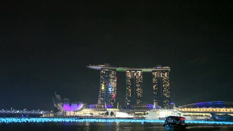 SINGAPORE - DEC 26: Lightshow on top of the Marina Bay Sands hotel at night from a boat on December 26, 2011 in Singapore.