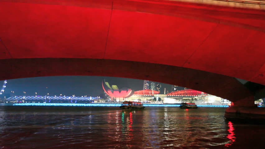 Boating through Singapore Marina Bay under a bridge with a view of the Opera,