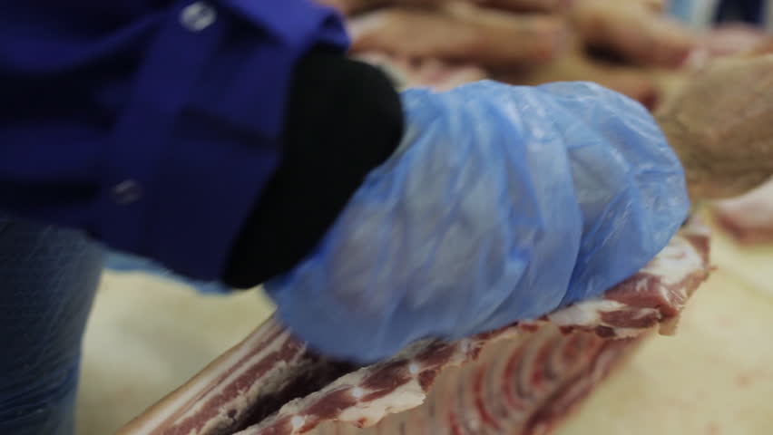 Butcher cuts the carcass of the pig on the table in the butcher shop | Shutterstock HD Video #32804245