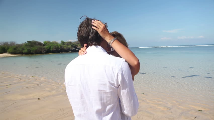 Cheerful couple kissing and embracing each other at beach