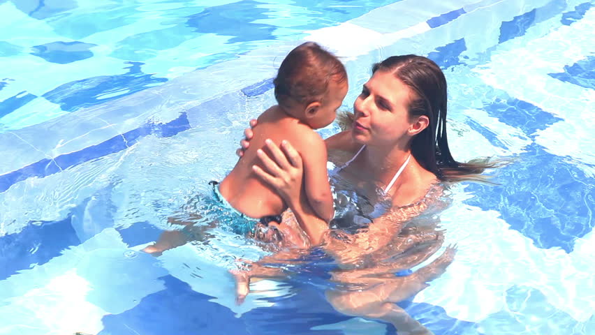 Happy pretty mother and her daughter have fun in swimming pool