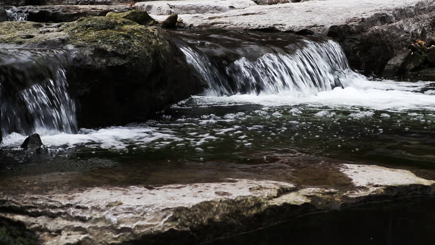 Waterfall flowing over rocks in nature. Peaceful water in nature.