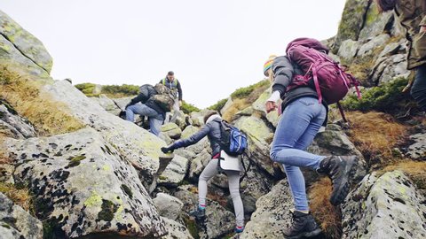 Backpackers climbing rocks