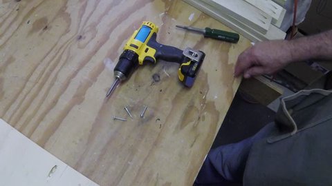 installing pocket hole screws in shelf to secure legs.