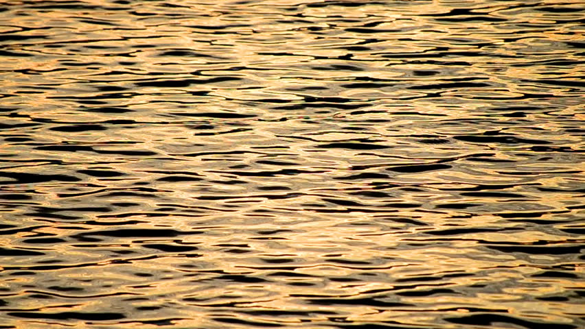 golden reflective light and ripples on river