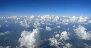 Airline passenger window perspective of fluffy. puffy. popcorn shaped clouds extending to the distant horizon. 4k DCI footage