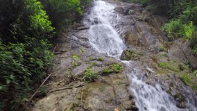 First person view of a hike. following and crossing a tropical. mountain stream and waterfall in Phuket. Thailand. UHD 4k video