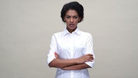 Displeased african woman in shirt expels someone and pointing away over gray background