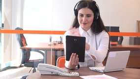 Professional young business woman in modern office interior video call on tablet