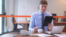 Young businessman manager in the office talking digital tablet video call happy