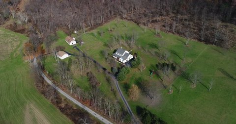 A high angle aerial flyover of a typical Western Pennsylvania farmhouse in the late Autumn.  	