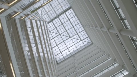 Abstract background shot looking up towards the ceiling of a glass building with cool geometric architecture