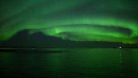 Brilliant wide aurora borealis reflecting over calm ocean and passing ship - Powered by Shutterstock - Get 15% off with code: PIKWIZARD15