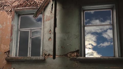 abandoned and ruined building. Windows of the house and clouds
