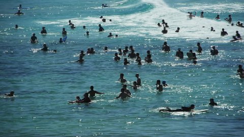 a backlit shot of swimmers enjoying the surf at bondi beach on a hot summer day