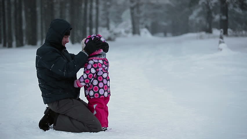 Father with small kid playing on snow together, winter in Russia