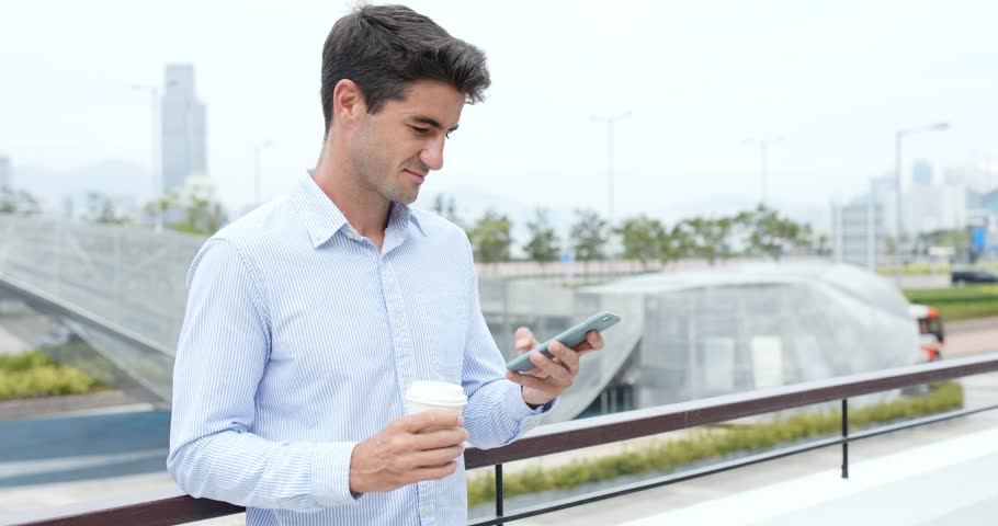 Businessman hold with cellphone and coffee cup