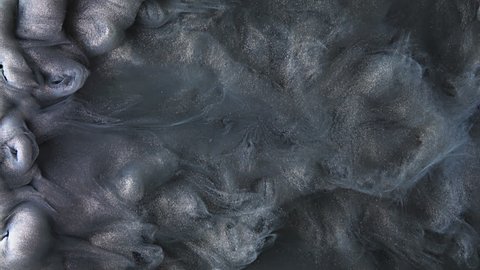 Colorful dark grey paint mixing in water. Ink swirling underwater. Cloud of silky ink. Colored abstract smoke explosion animation. Close up macro view