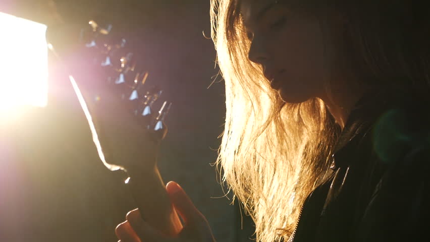 woman Guitarist silhouette in a backlights in the smoke playing solo and sing Royalty-Free Stock Footage #32877019
