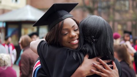 Graduation With Happy Black Graduate Female Hugged By Proud Mother. In Slow Motion.