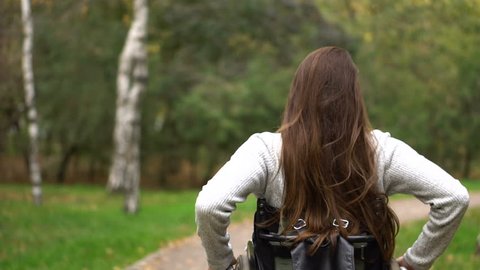Attractive girl on a wheelchair walking in the autumn park. 