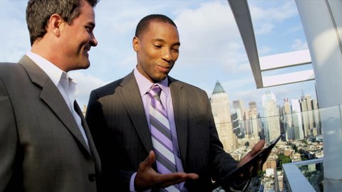 Handshake of diverse ambitious business colleagues analyzing finance on touch screen technology on rooftop overlooking city shot on RED EPIC