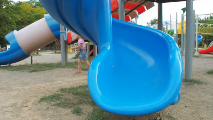 Happy children on the playground. A little girl is riding on a baby crust.